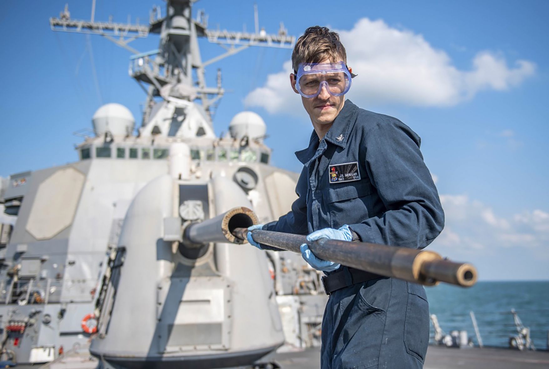 Rossville sailor cleans barrel of artillery gun aboard Navy destroyer